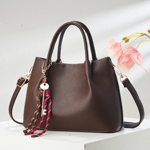 Elegant dark brown pebble leather tote bag with gold key charm and adjustable strap