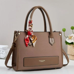 Detailed side view of brown tote bag featuring texture fabric and floral scarf detail