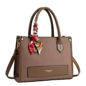 Brown woven texture tote bag with silk scarf and adjustable strap on white background