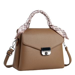 Sac bandoulière marron en cuir grainé avec foulard en soie sur la poignée élégante