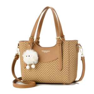 Women's straw bucket bag with brown leather trim and cute plush charm for daily commute