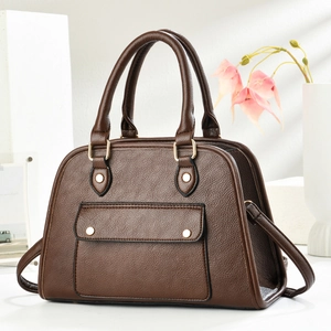 Gros plan d'un sac à main marron en cuir litchi avec détails de rivets dorés