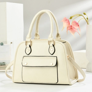 Détails du sac à main beige texture litchi avec clous dorés et bordures peintes
