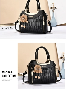 Détails du sac à main noir tressé avec finitions dorées et pendentif lion décoratif