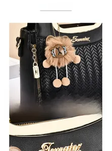 Détail du sac en cuir PU grainé avec texture tissée, logo en métal et breloque ours