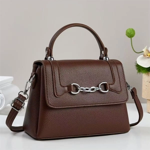 Dark brown pebbled leather satchel with horsebit buckle and top handle shown in 45-degree angle