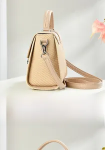 Detail view of beige structured handbag featuring woven side texture and adjustable strap