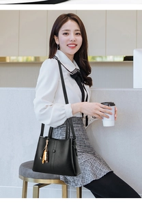 Chic black pebble leather shoulder bag with colorful beaded tassel in a lifestyle setting