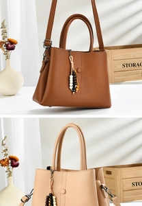 Detail view of large faux leather tote bags in brown and beige with boho bead charms