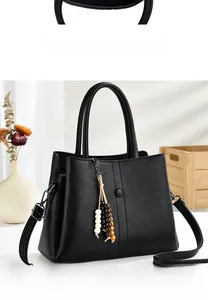 Front view of black pebble leather tote bag with stylish wooden bead tassel and strap