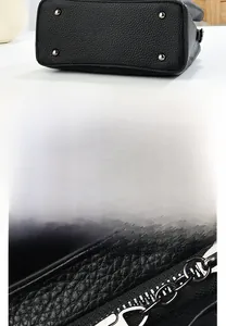 Detail view of the black lychee leather bag base with four metal protective rivets and zipper