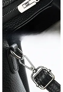 Macro shot of silver metal zipper and D-ring on black lychee grain leather handbag