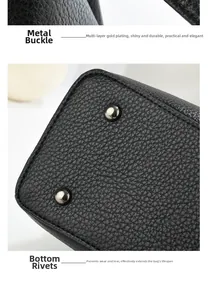 Detail of gold-plated buckle and protective metal studs on black litchi leather bag