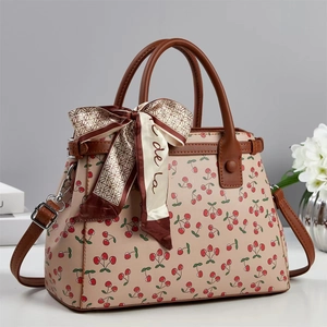 Elegant beige tote bag with cherry print, brown leather handles and decorative silk scarf