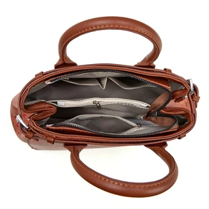 Top-down view of brown leather tote with three compartments and cherry print side detail