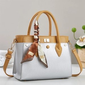 Silver textured tote bag with brown straps and a decorative floral scarf detail