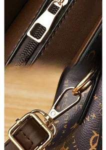 Detail view of premium golden zipper hardware and brown monogram leather handbag strap