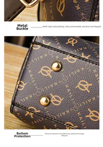 Detail view of gold-plated metal buckles and protective bottom feet on a brown leather handbag