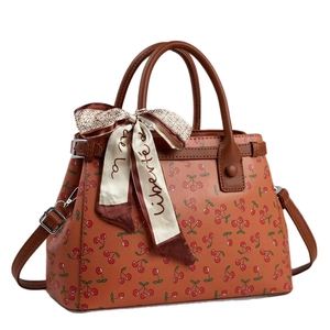 Vintage brown tote bag with cherry print and silk scarf on white background