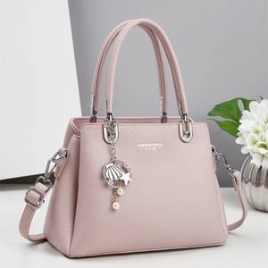 Detailed view of pink lychee leather handbag with silver hardware and pearl charm