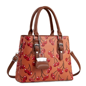 Fashionable cherry print shoulder bag with brown top handle and mini charm accessory