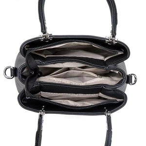 Interior view of black leather handbag with grey lining and multiple storage compartments