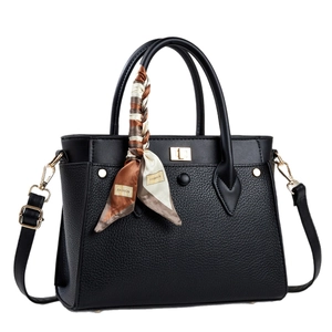Black leather tote bag with gold lock, scarf handle, and adjustable shoulder strap