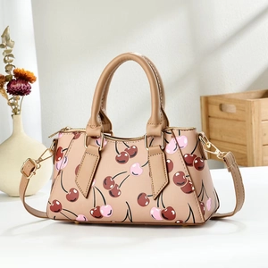 Stylish beige crossbody bag featuring sweet red cherry patterns and gold-tone hardware