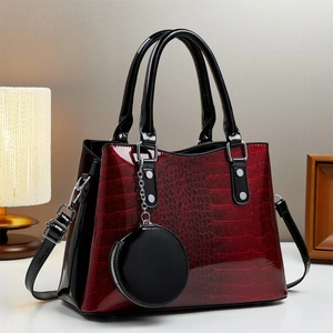 Dettaglio borsa con texture coccodrillo bordeaux lucido e accenti in metallo argento