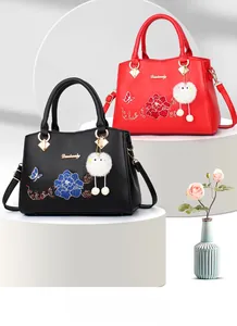 Elegant handbag with Chinese floral embroidery and white faux fur pom-pom detail