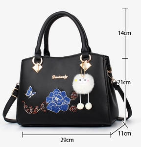 Detail of black leather handbag with blue embroidery and 29x21x11cm dimensions