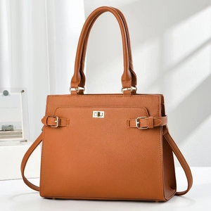 Brown litchi grain leather tote bag with gold turn-lock closure in an elegant room setting
