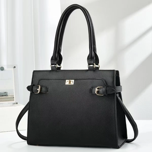 Detail of black pebbled leather tote bag featuring gold twist-lock and side strap accents