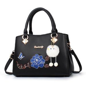 Elegant black faux leather handbag for elderly women with blue flower embroidery and plush charm