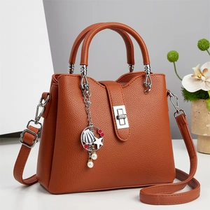Elegant orange-brown pebbled leather handbag with silver lock and detachable strap