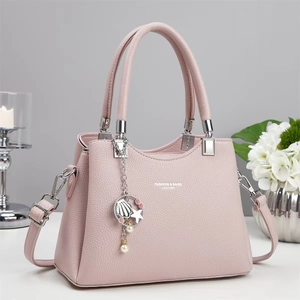 Detail of pink lychee leather handbag with silver hardware and shell star charm