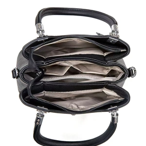 Interior view of black pebbled leather tote with multiple compartments and silver hardware