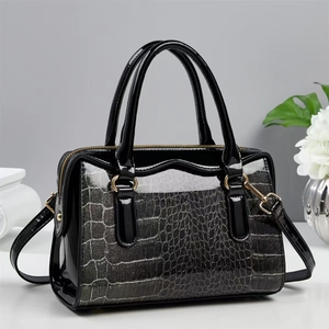 Close-up of black crocodile pattern handbag with silver glitter finish and gold hardware
