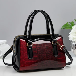 Detail of red and black gradient crocodile pattern Boston bag with gold hardware