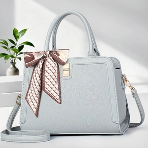 Close-up of light blue lychee pattern tote bag with decorative silk scarf and gold hardware