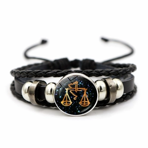 Detailed macro view of Libra zodiac leather bracelet with black braided cords and glass gem