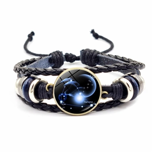 Détail d'un bracelet en cuir multicouche avec un cabochon en verre du Capricorne
