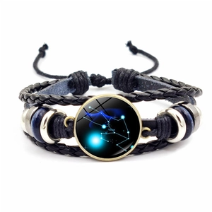Détail de bracelet multicouche en cuir avec cabochon en verre du signe Taureau