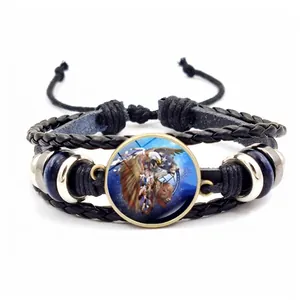 Detail of multi-layer woven bracelet featuring tribal eagle pattern and blue beads