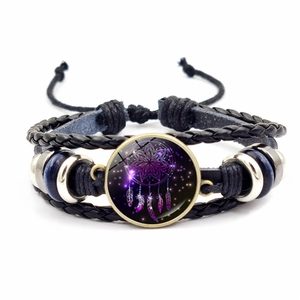 Detail of multi-layer woven bracelet with purple dreamcatcher glass cabochon