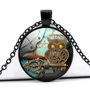 Macro shot of steampunk owl and key pendant with brass finish and glass dome