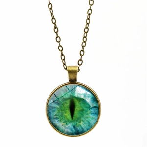 Detailed close-up of retro green dragon eye pendant with antique bronze alloy chain