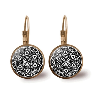 Dettaglio di orecchini mandala in bronzo con cabochon geometrico in vetro bianco e nero