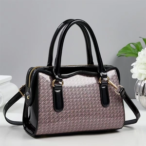 Close-up of pink glitter texture with black patent leather trim and gold metal hardware