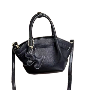 Minimalist black lychee pattern leather handbag with cute dog charm and crossbody strap